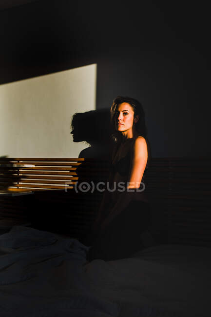 Sinnliche hübsche Frau spielt in Dessous zwischen Licht und Schatten — Stockfoto