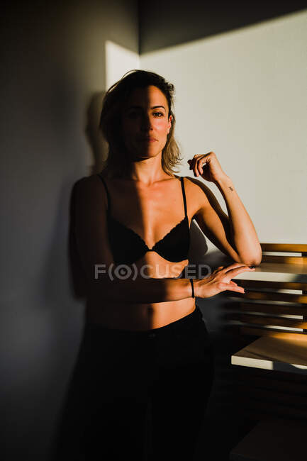 Mujer bonita sensual jugando entre la luz y la sombra en lencería - foto de stock