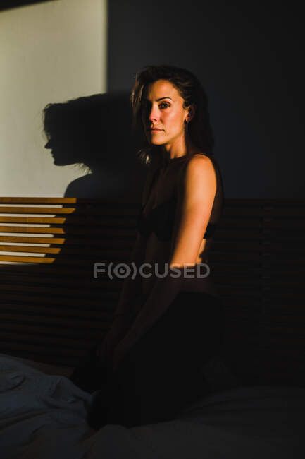 Mujer bonita sensual jugando entre la luz y la sombra en lencería - foto de stock