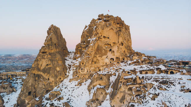 Вид згори на грубі скелі вкритий білим снігом проти безхмарного вечірнього неба в Каппадокії (Туреччина). — стокове фото
