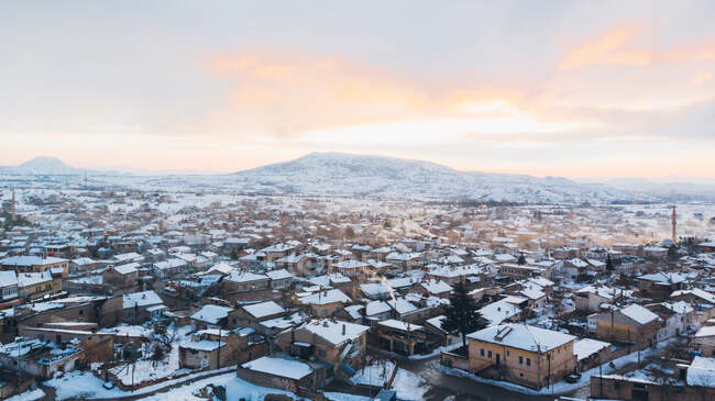 Dall'alto vista aerea della città innevata con antichi edifici della casa intemperie contro cielo sordo coperto in inverno in Turchia — Foto stock