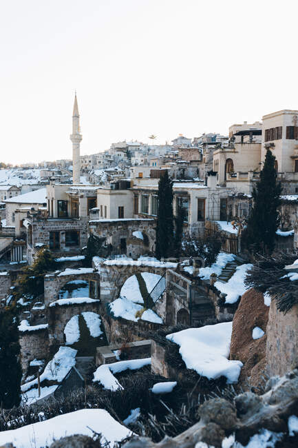 Старі вежі і кам'яні будівлі, вкриті білим снігом, розташовані на безхмарному небі в зимовий вечір у місті Туреччина. — стокове фото