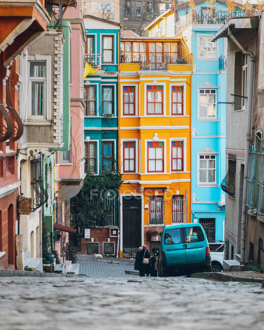 Camino pavimentado cerca de casas coloridas y coche azul en la calle de la ciudad en Turquía - foto de stock