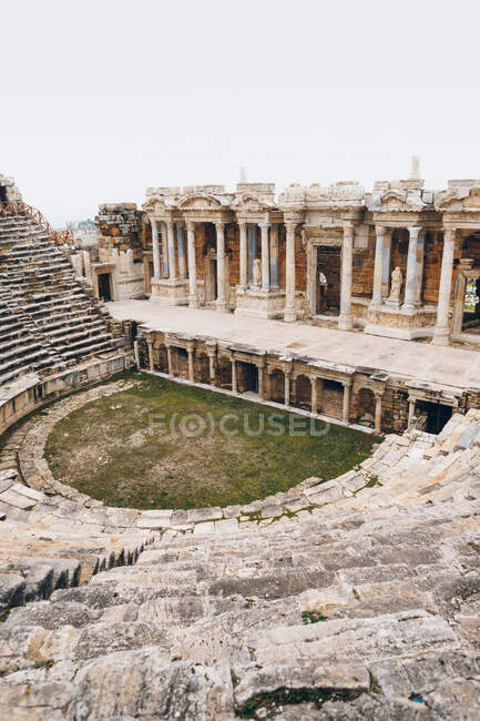 From below gray air balloon racing in cloudy sky over abandoned ancient palace with amazing architecture including columns and statues in overcast weather in Turkey — Stock Photo