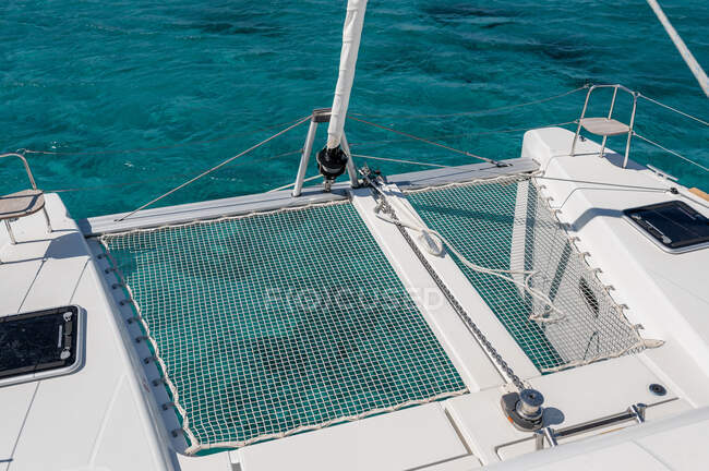 De cima da rede no convés do catamarã moderno que navega no mar no dia ensolarado no verão — Fotografia de Stock