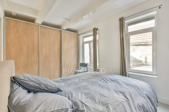 Vista laterale di un grande letto con morbidi cuscini — Foto stock