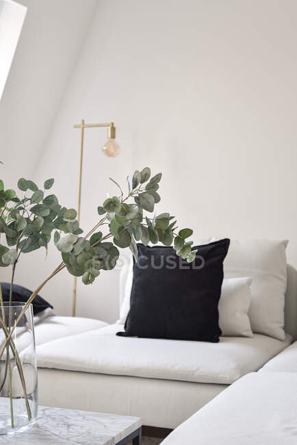 Close up de sofá com travesseiros à mesa com uma flor — Fotografia de Stock