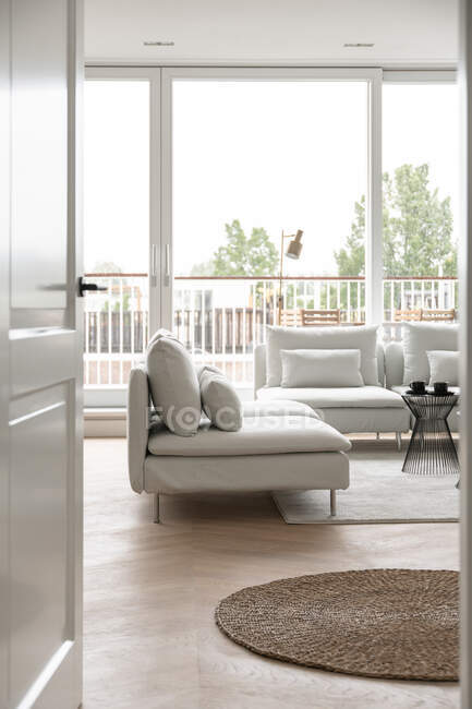 Vista da porta para uma sala de estar com sofá elegante — Fotografia de Stock