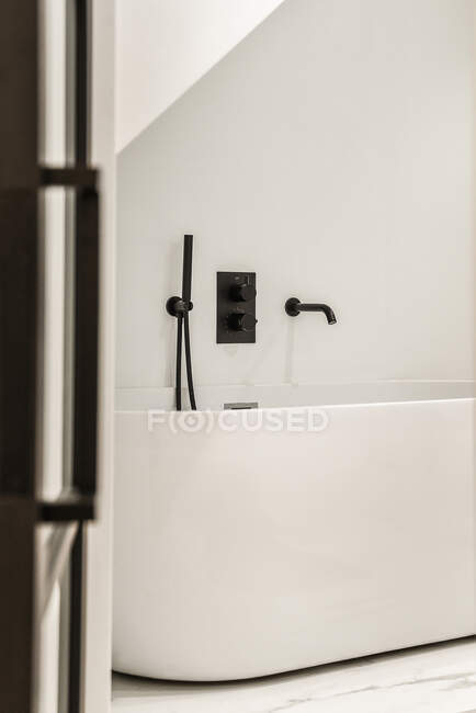 Светлая ванная комната с декоративной ванной роскошного дома — стоковое фото
