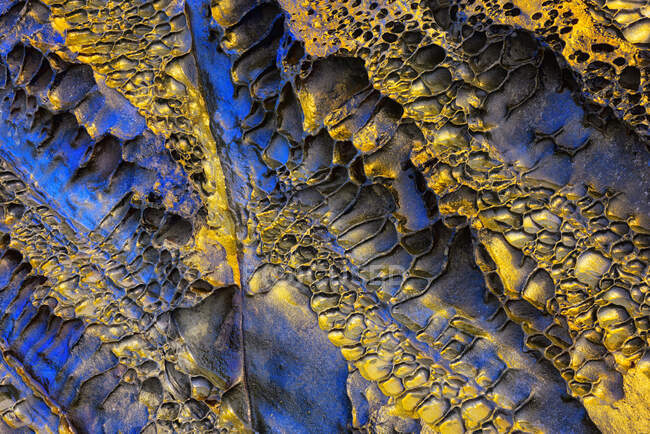 Texture with gold and blue tones of an eroded cliff — Stock Photo