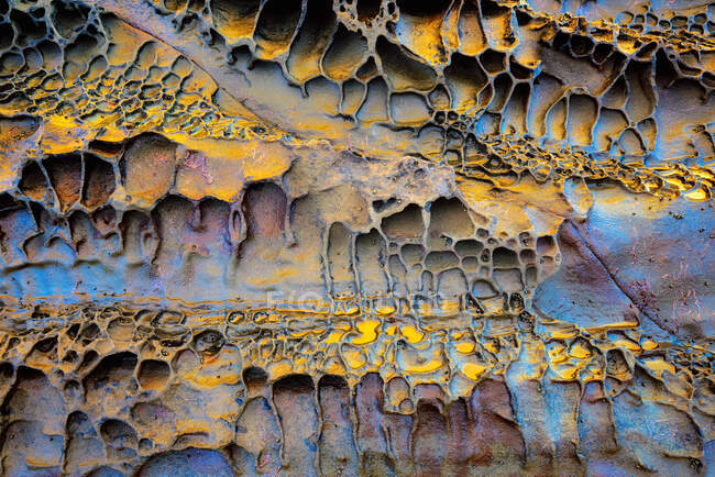 Текстура с золотыми и голубыми тонами эродированной скалы — стоковое фото