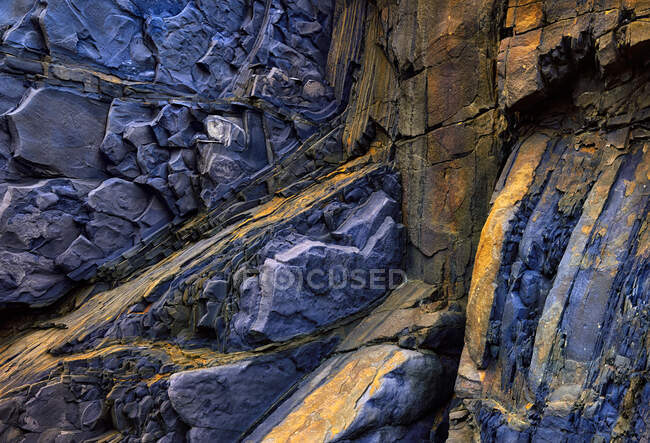 Fondo áspero texturizado de roca sedimentaria de colores azul y rosa con superficie desigual - foto de stock