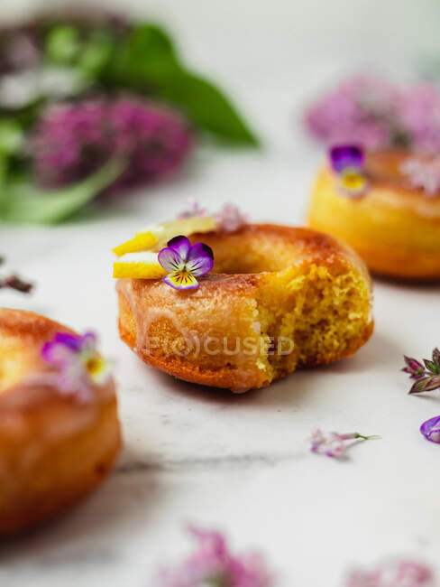 De haut de beignets délicieux avec des tranches de citron frais et des fleurs de Lavandula sur la surface du marbre — Photo de stock