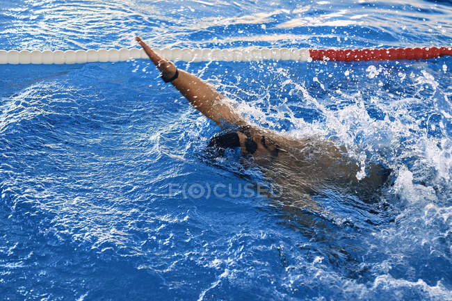 High angle of fit male swimming in crawl style in pool during training — Stock Photo