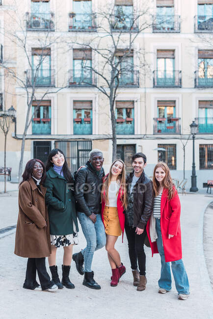 Gesellschaft fröhlicher multiethnischer Freunde in stylischer Kleidung, die am Wochenende gemeinsam in der City Street vor der Kamera stehen — Stockfoto