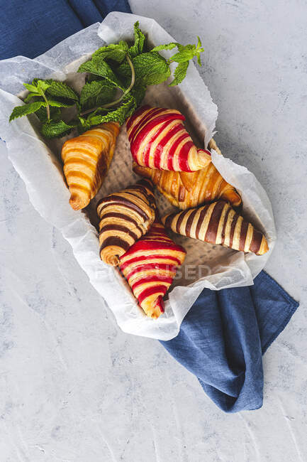 De dessus de croissants sucrés assortis servis dans le panier sur la table pour le petit déjeuner — Photo de stock