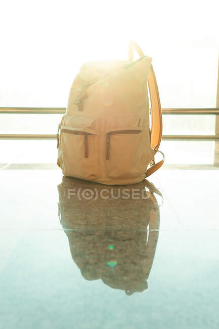 Reiserucksack auf dem Boden neben Fenster in Abflughalle in modernem Flughafen platziert — Stockfoto