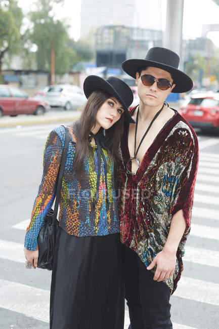 Selbstbewusstes stylisches Paar in Hipster-Klamotten steht im Sommer umarmt auf der Straße und blickt in die Kamera — Stockfoto