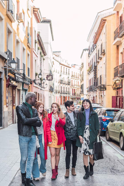 Компанія щасливих багаторасових друзів у стильному одязі, що ходить разом на міській вулиці у вихідні — стокове фото
