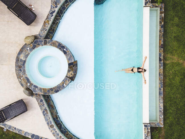 Вид зверху жінка сама в басейні насолоджується сонячним літнім днем — стокове фото