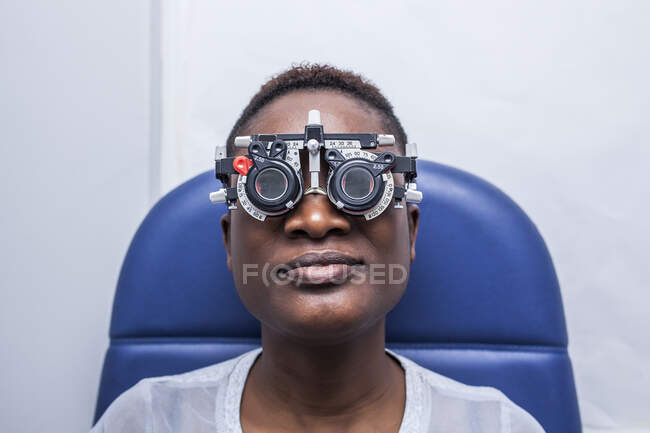 Mujer negra en el gabinete de optometría durante el estudio de la vista - foto de stock
