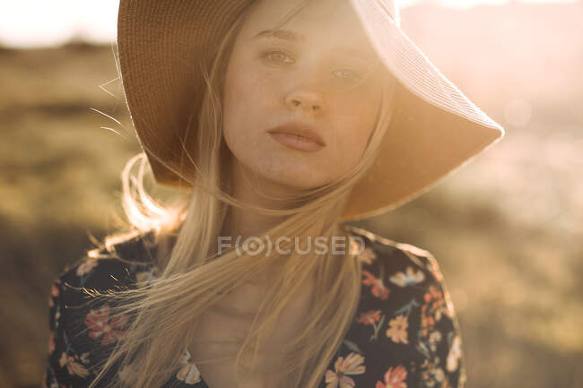 Retrato de uma bela jovem mulher alegre com chapéu no campo olhando para a câmera sorrindo — Fotografia de Stock