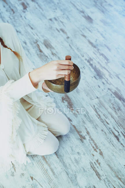Mujer de las cosechas jugando tazón de canto con el delantero de madera durante la práctica espiritual - foto de stock