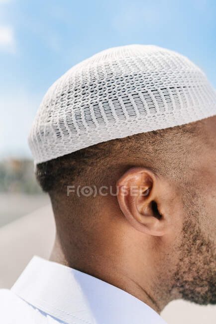 Anonymer islamischer Mann mit authentisch gestrickter Kopfbedeckung steht an einem sonnigen Sommertag auf verschwommenem Hintergrund — Stockfoto