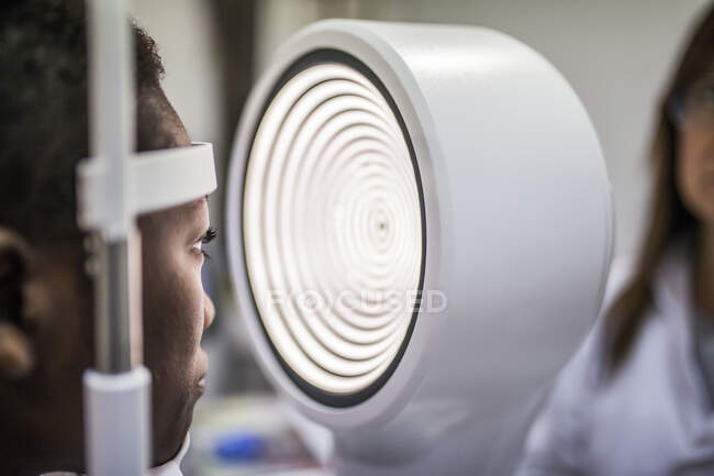 Черная женщина в шкафу оптометрии во время изучения зрения с помощью современного топографа роговицы — стоковое фото