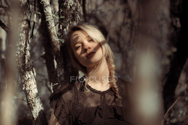Porträt einer jungen schönen blonden Frau in einem Wald, dramatische Beleuchtung im Gesicht — Stockfoto