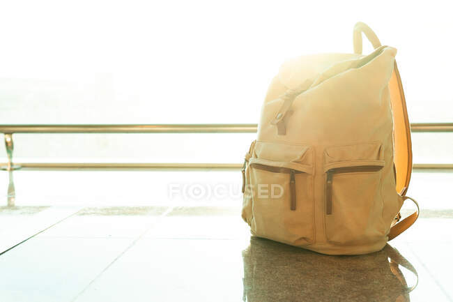 Трассовый рюкзак положили на пол у окна в аэропорту вылета — стоковое фото