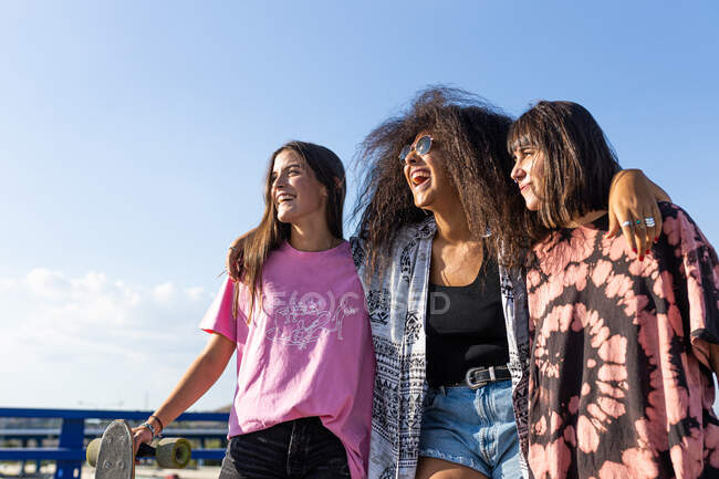 Três mulheres jovens bonitas de raças diferentes com suas pranchas longas e sorrindo — Fotografia de Stock