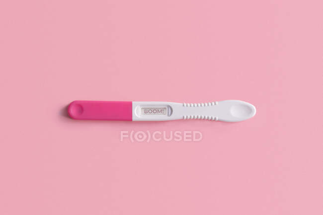 Вид зверху на тест на вагітність, розміщений на рожевому тлі — стокове фото