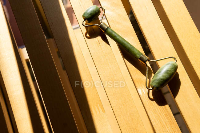 Von oben Jade-Walze für Wellness-Behandlung auf Holzbank zu Hause platziert — Stockfoto