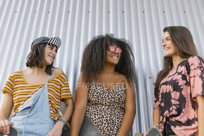Tre belle giovani donne di razze diverse con le loro tavole lunghe e sorridenti — Foto stock