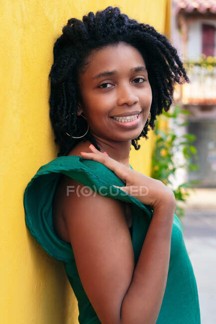 Fechar de cabeça retrato de bela sorridente jovem mulher negra encostada contra a parede fora — Fotografia de Stock