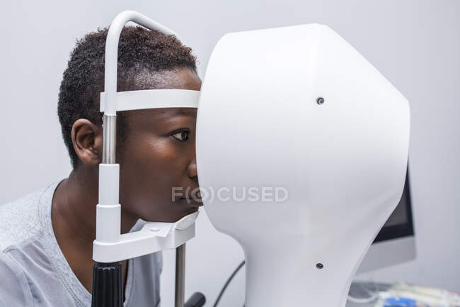 Черная женщина в шкафу оптометрии во время изучения зрения с помощью современного топографа роговицы — стоковое фото