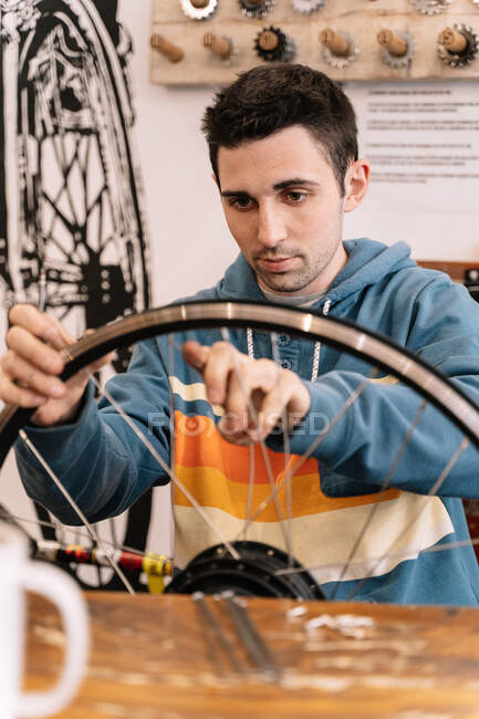 Під час їзди на велосипеді Серйозний чоловічий механік ремонтував колесо. — стокове фото