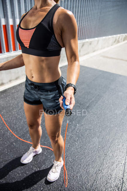 Unrecognizable woman training with the outdoor skipping rope , side view — Stock Photo