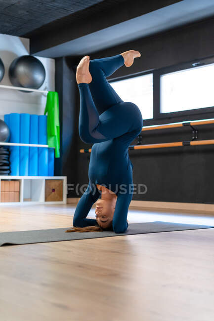 Corpo completo di vestibilità femminile in abbigliamento sportivo facendo poggiatesta sostenuto variazione posa durante la pratica dello yoga in palestra — Foto stock