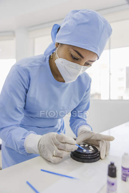 Dentiste féminine avec outil de préparation des placages pour l'intervention en clinique — Photo de stock