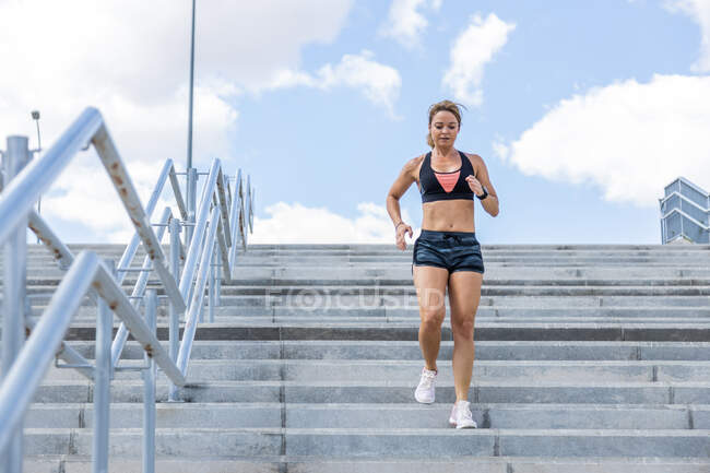 Unrecognizable woman training outdoors downstairs, front view — Stock Photo
