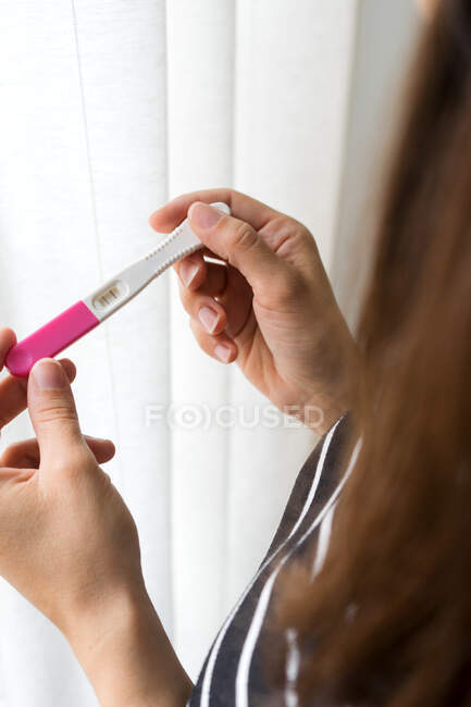Прозорені невпізнавані жінки, які проводять обстеження вагітності, крім вікна. — стокове фото