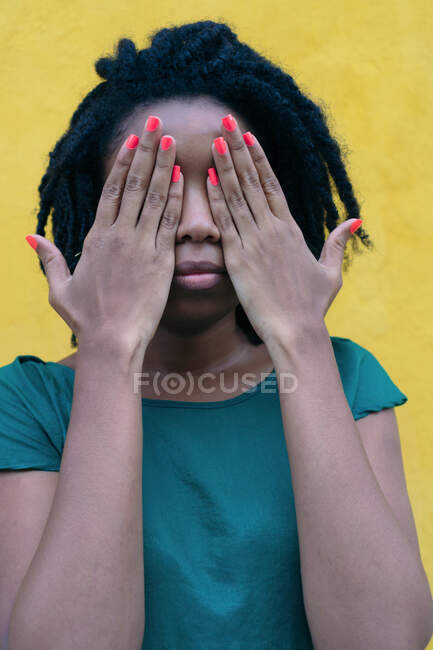 Retrato de una mujer negra cubriéndose los ojos en la calle - foto de stock