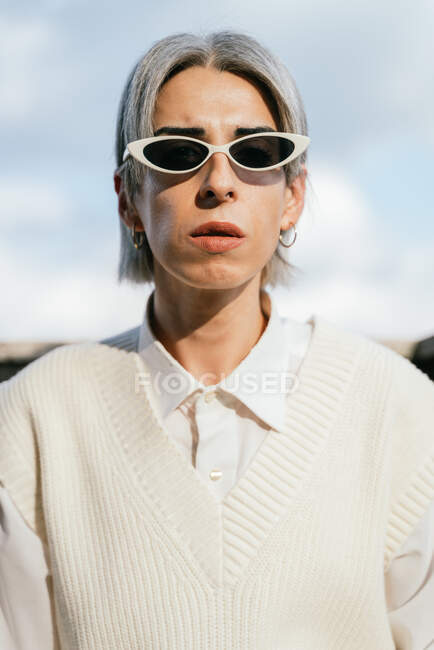 Confident transgender female in trendy outfit standing on terrace and looking at camera — Stock Photo