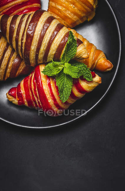 De cima de croissants doces variados servidos na cesta na mesa para o café da manhã — Fotografia de Stock