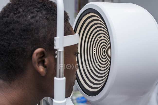 Donna nera in gabinetto di optometria durante lo studio della vista usando un topografo corneale moderno — Foto stock