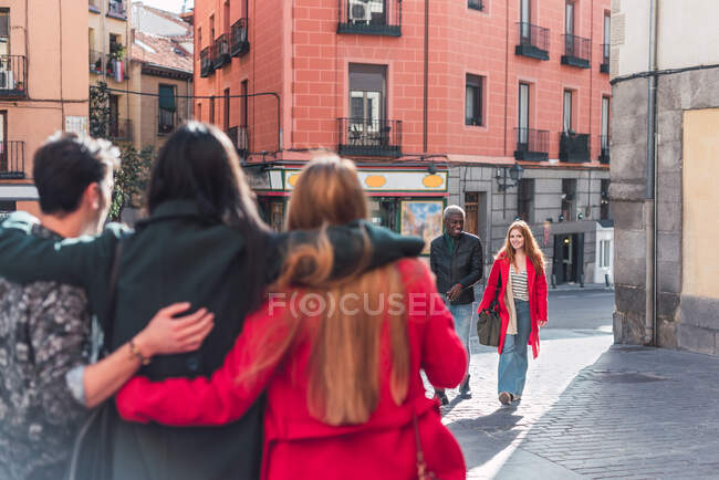 Grupo de amigos diversos alegres em pé na rua da cidade e desfrutando de fim de semana juntos — Fotografia de Stock