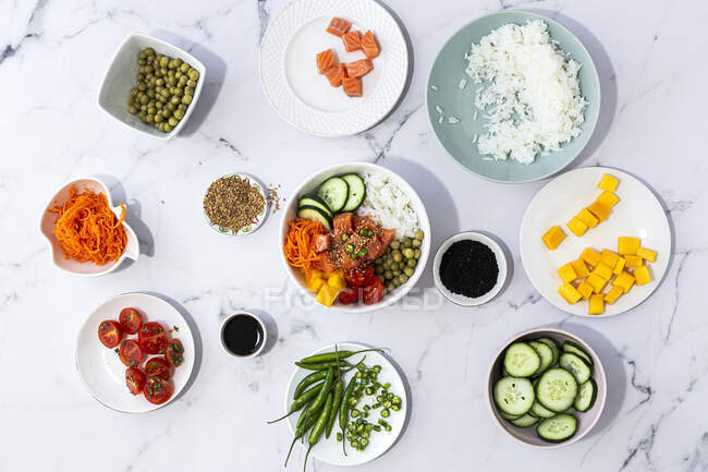 Top view of assorted fresh ingredients for traditional oriental poke preparation placed on marble tabletop — Stock Photo