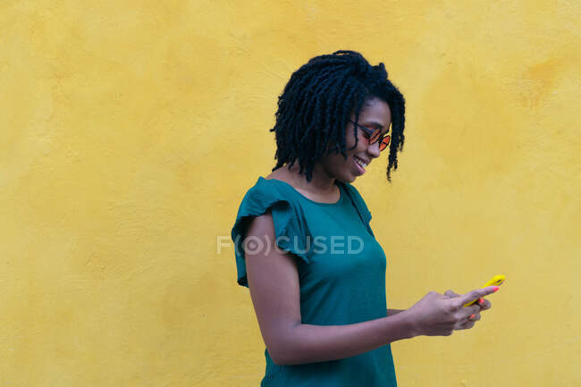 Портрет молодої жінки, що надсилає повідомлення про смартфон на вулиці . — стокове фото